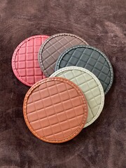 luxury quality titanium galaxy car matt pvc leather shining gloss carpet in red brown black grey blue green maroon color texture round shape on dark brown carpet background