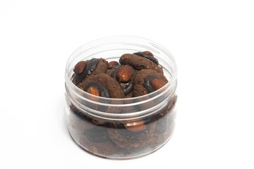 Afghan cookies made from chocolate and cornflakes with almond on top in a jar isolated on white background clipping path