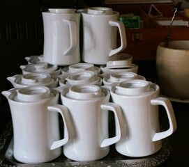 Stapel weißer kleiner Kaffeekannen in Café