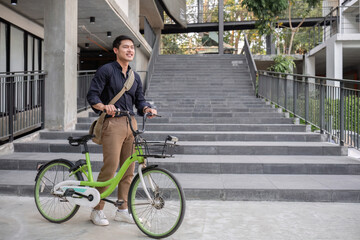 Obraz premium Young Asian businessman Go to work by cycling to reduce air pollution and stay healthy.