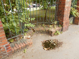old metal fence with a brick foundation, fragment arched in relation to the fence line