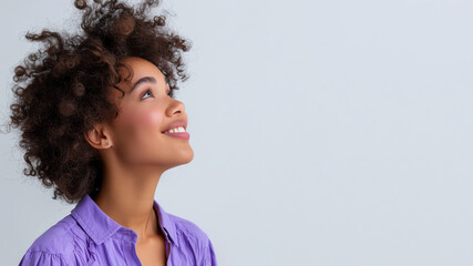 Afro woman wearing purple shirt smile looking up isolated on gray