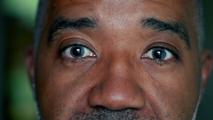 African American senior man close-up eyes reacts with SHOCK and surprise, macro tight portrait of a...