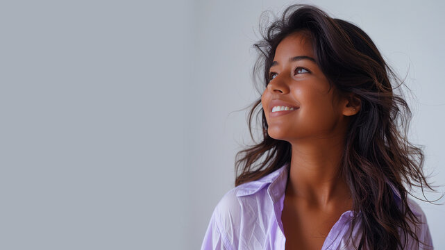 Indian woman wearing purple shirt smile looking up isolated on gray