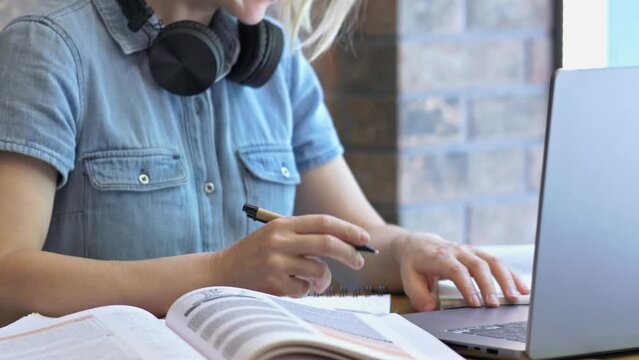 Sitting at desk with laptop books notes student makes notes on paper. Makes notes common practice during studying allowing students highlight key points better understanding of material making notes
