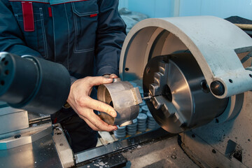 A worker works on a lathe at a machine-building plant.