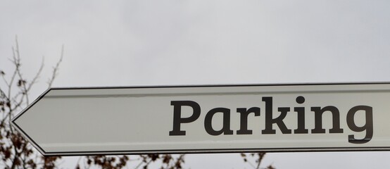 A close view of the white and brown parking sign.