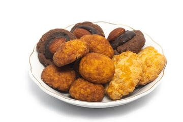 Assorted cookies of palm cheese and cornflakes and afghan cookies in a small white plate isolated...