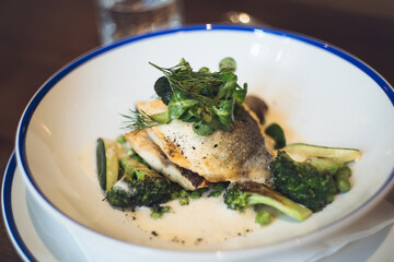 Sea bass fish fillet with grilled green vegetables and citrus sauce
