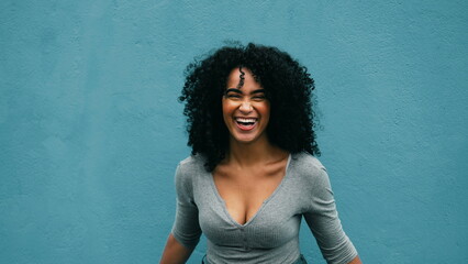 Joyful South American young woman laughing and smiling. authentic burst of laughter of a black...