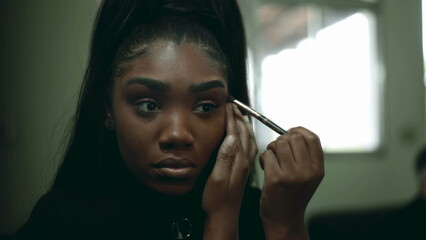 One Black Latina Young Woman Applying Makeup in Front of Mirror, Adult 20s Girl of African Descent Getting Ready to Go Out
