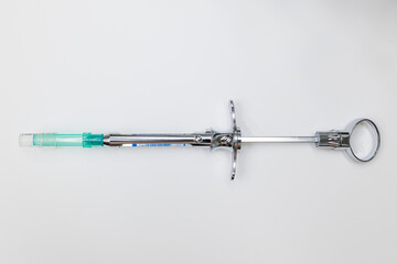 Dentist holding anesthetic syringe in clinic, Steel dental syringe for local anesthesia, isolated on white. Carpool syringe for anesthesia in dentistry. Thin needle on a syringe for anesthesia in dent