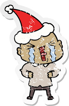 distressed sticker cartoon of a crying bald man wearing santa hat