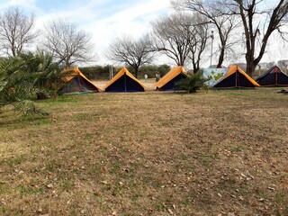 Campamento con carpas naranjas y azules en fila en un día de invierno