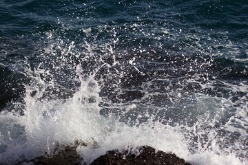 Sea waves spattering on the rocky shore