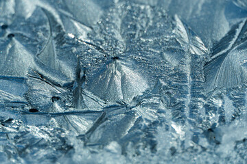 Ice flowers on a roof window at sunrise