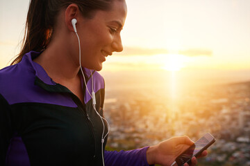 Happy woman, fitness and earphones with phone in sunset for music, podcast or listening to audio in...