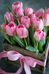 Close-up of pink tulips bouquet in a wooden box, ideal for spring holidays.