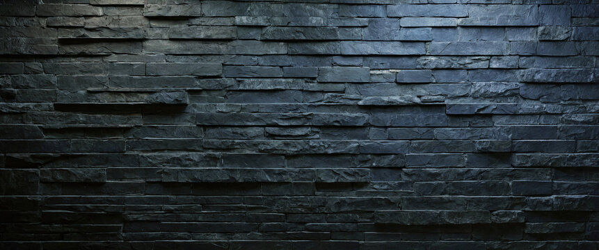 Background and texture of black blue stone brick with light illuminated in places. Panorama.