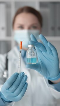 A doctor holding a syringe with an antiviral drug prepares for vaccination, emphasizing the importance medical profession and fight against diseases. Health care and disease prevention during epidemic