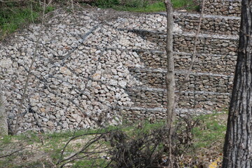 A multi-tiered stone wall held in place by welded wire rod keeps a major urban creek of the Trinity RIver Watershed from further erosion. 