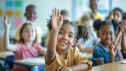 Fototapeta premium Primary school diverse cheerful smiling children sitting in light classroom with their hands up eager to answer the teacher's question