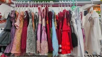 Colourful girl clothes displayed on display rack in the inventory store to attract customer to buy