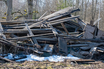 broken old wooden building in countryside. Pile of wooden planks