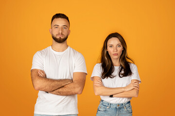 Serious and confident young man and woman in white t-shirts with arms crossed