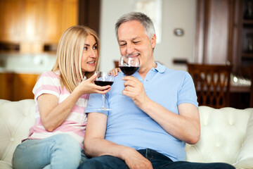 Mature couple enjoying red wine at home