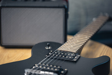 Black electric guitar and speaker close-up. Guitar amplifier, musical equipment.