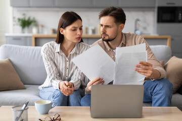 Young couple reviewing documents with concern