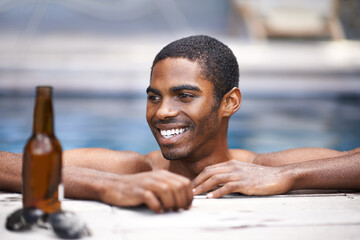 Man, beer and relax poolside, happy and swimming on weekend for wellness on summer holiday. Black...