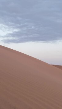 A majestic desert landscape unfolds at sunrise in the Sahara, Africa. Golden sands, lonely dunes, and a remote, tranquil wilderness embody the extreme climate and beauty of this arid land.