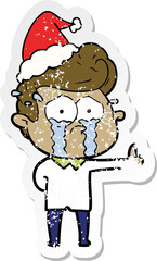 distressed sticker cartoon of a crying man wearing santa hat