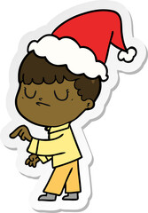 sticker cartoon of a grumpy boy wearing santa hat