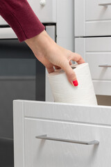 Fototapeta na wymiar woman taking out paper towel from kitchen drawer.