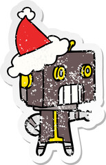 distressed sticker cartoon of a robot wearing santa hat