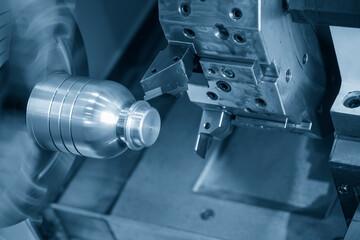 The  CNC lathe machine forming  cutting the metal shaft parts in the light blue scene.
