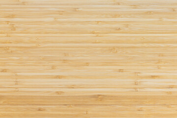 Bamboo wood texture background. Woodgrain of a board as empty copy space. Natural tropical material close up of a furniture part.
