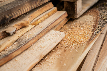 Cut wooden lumber boards at carpenters with a lot of sawdust on the different types of wood. Timber...