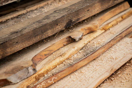 Cut wooden lumber boards at carpenters with a lot of sawdust on the different types of wood. Timber wood planks on top of each other outside the carpentry