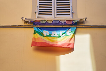 A rainbow flag with the word peace painted in blue, displayed as a creative arts fixture in a...