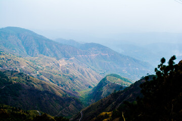Obraz premium Beautiful curvy Road on the mountains of Lansdowne, Uttarakhand. Aerial view of amazing curved road through the mountains.