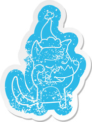 friendly cartoon distressed sticker of a fox waking up wearing santa hat