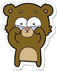 sticker of a cartoon crying bear rubbing eyes