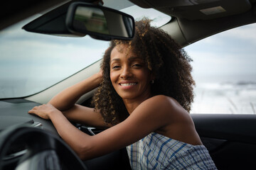 Portrait of a lovely and beautiful black woman relaxing inside the car during a getaway. - 751568805
