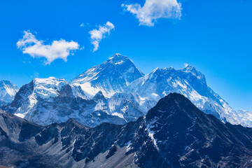 Stunning photo of highest peak on earth,  8848 meter high Mount Everest along with Lhotse and Nuptse against the bright blue sky in this view from Gokyo Ri in Nepal - obrazy, fototapety, plakaty