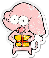 distressed sticker of a cute cartoon elephant with christmas present