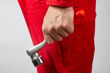 A worker holds a socket wrench in his hand.